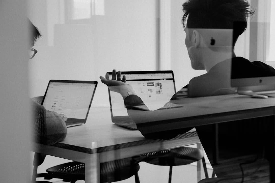Two businesspeople shaking hands across a conference table