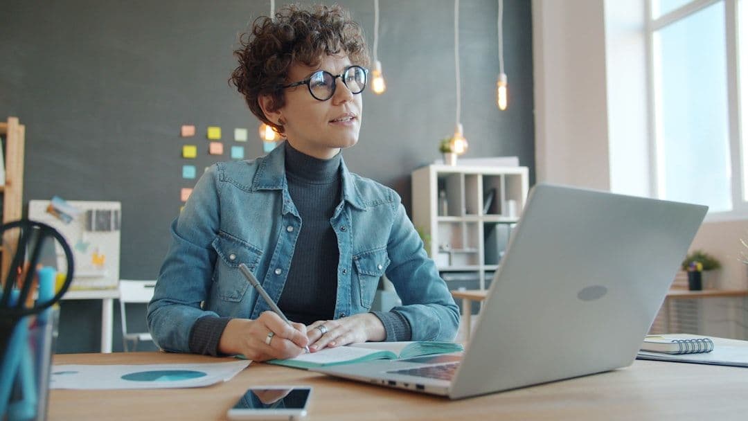 A young professional reviewing their resume on a laptop at a desk