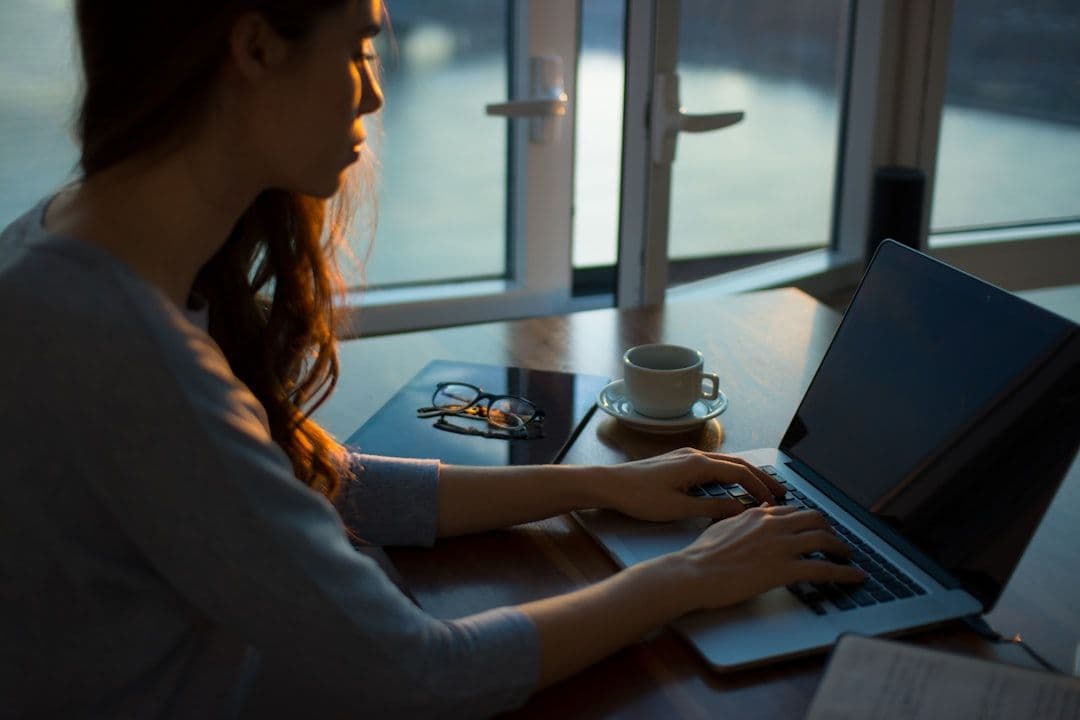 A professional woman reviewing a document on her laptop at a desk