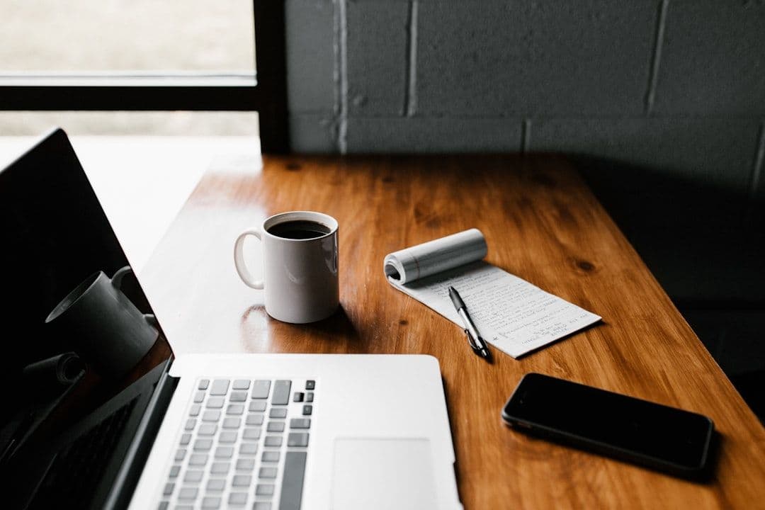A resume draft on a desk next to a notebook and coffee cup