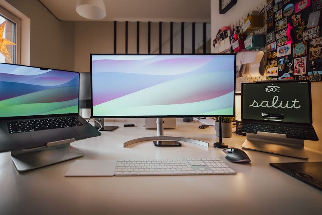 Modern graphic designer workspace with multiple monitors showing design software and creative projects