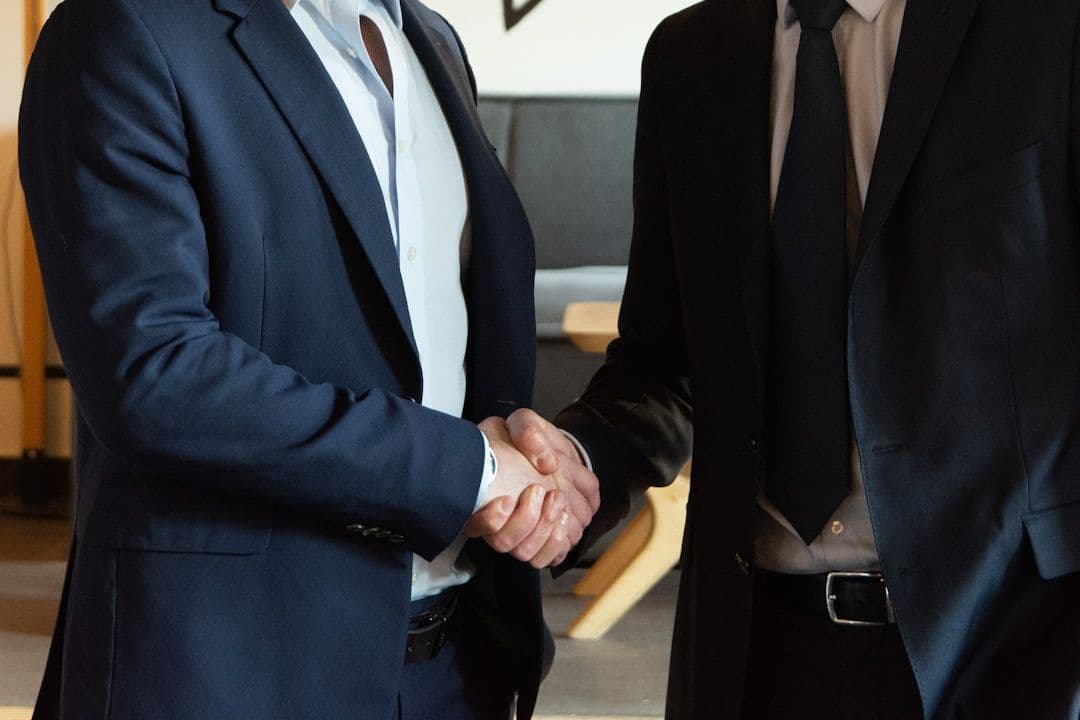 Two professionals shaking hands in modern office setting