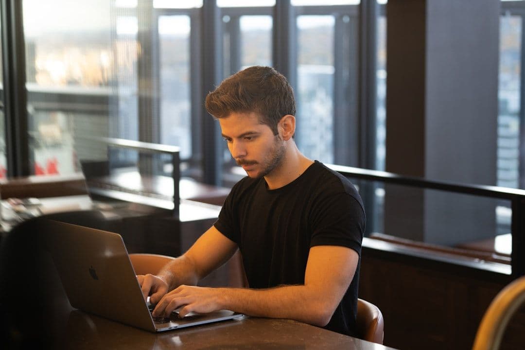 Professional reviewing resume document on a laptop at a desk